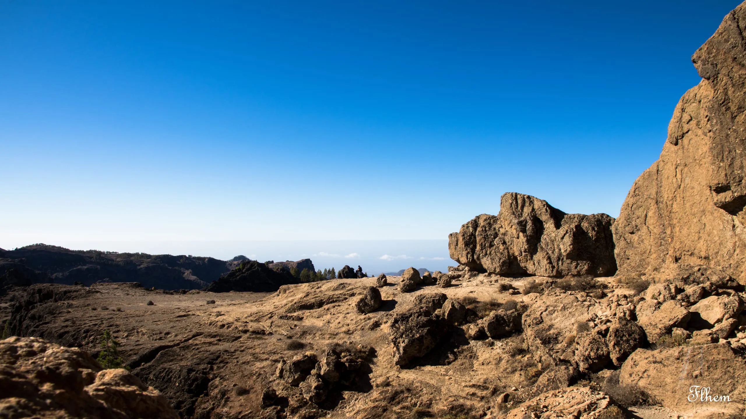 Plateau de roches ocres et blocs érodés sous un ciel bleu intense