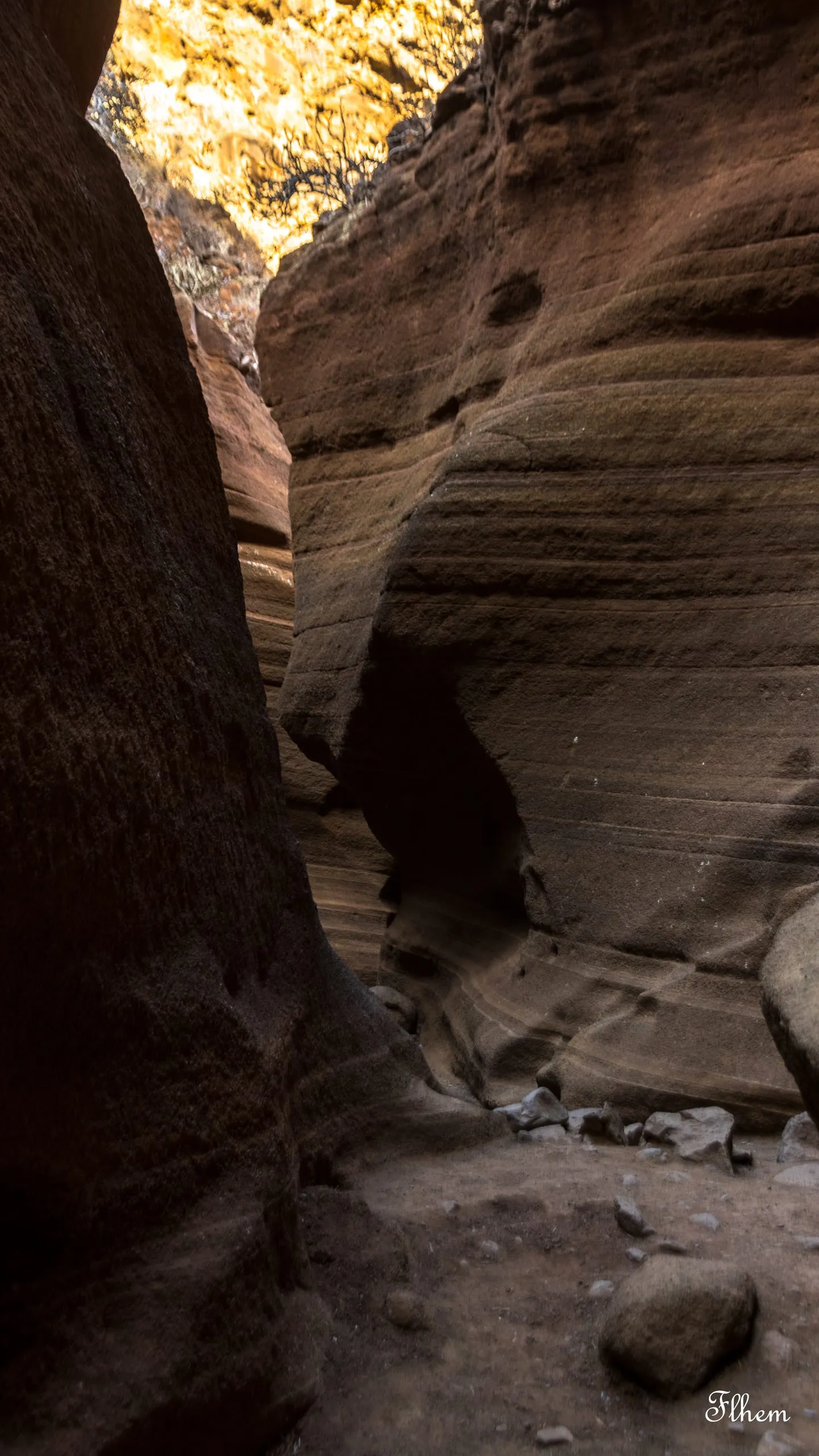 Étroit canyon de roche aux parois ondulées et striées, éclairées par le soleil en haut